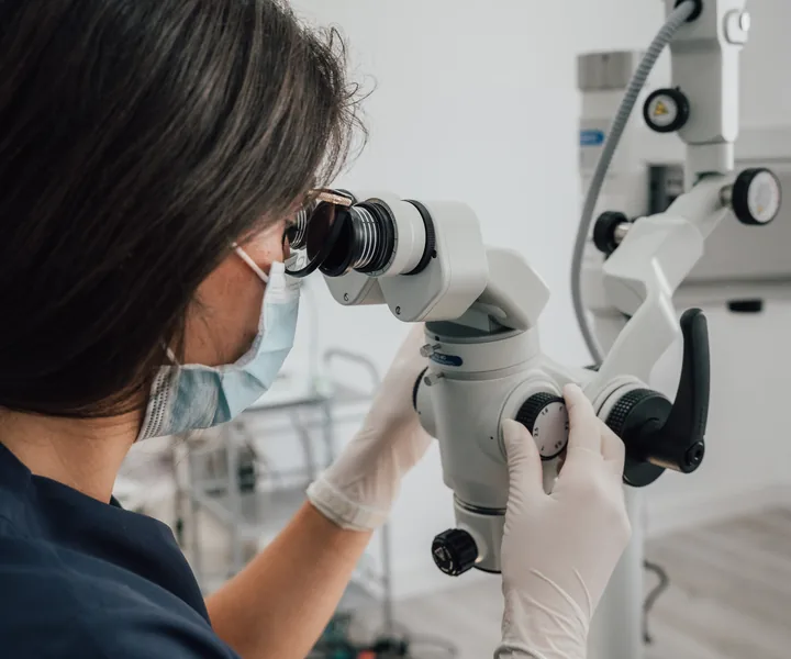 Endodoncista trabajando con microscopio
