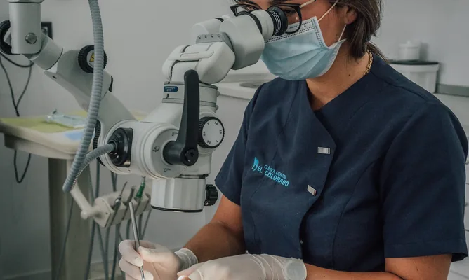 Endodoncista tratando a una paciente con microscopio
