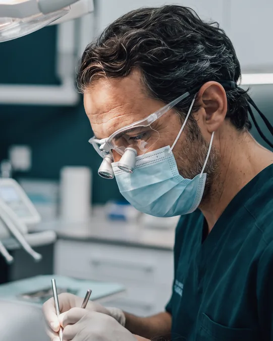 El Dr. Martínez Molina trabajando con lupas de magnificación